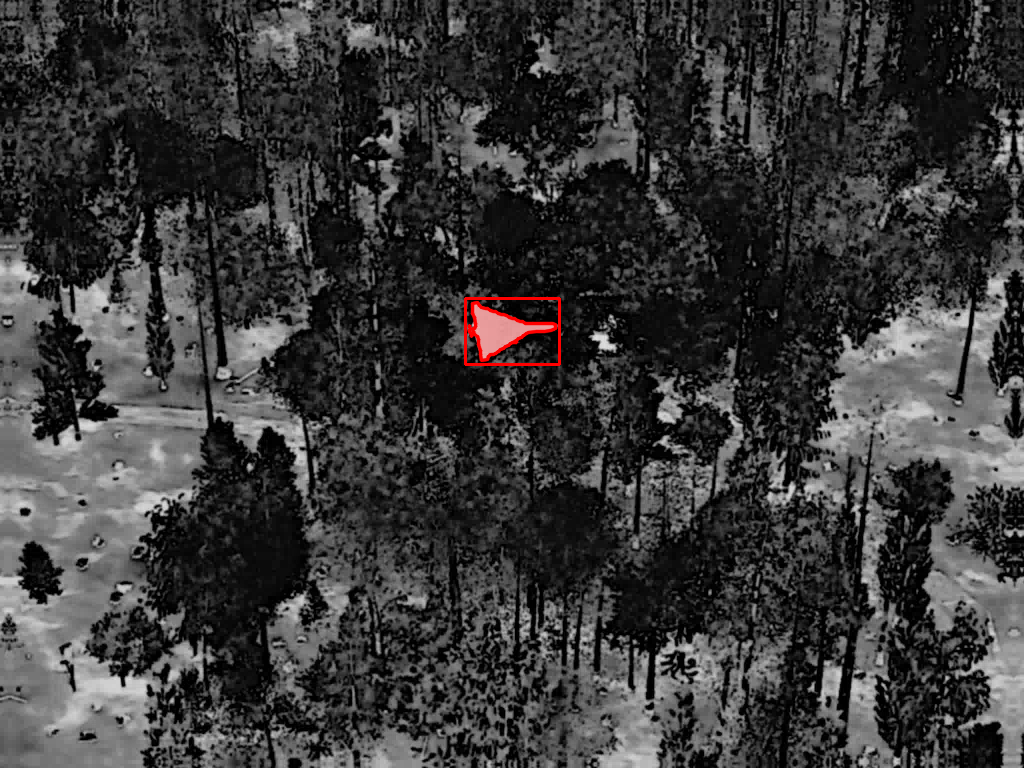 Delta-wing aerial threat detected in thermal imagery over forest, detection box locked